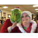 Mrs. Claus smiles next to someone in a Grinch mask