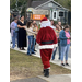 Santa walking outside to greet a line of parents and children