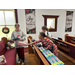 a girl reaches over a pew filled with toys to hand a toy to another child