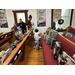 a young child rides a bike between church pews filled with toys