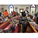 children and workers stand in a church with pews filled with toys