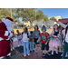 Santa greets a line of children outside