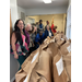 a group of adults stand next to a long line of brown paper bags